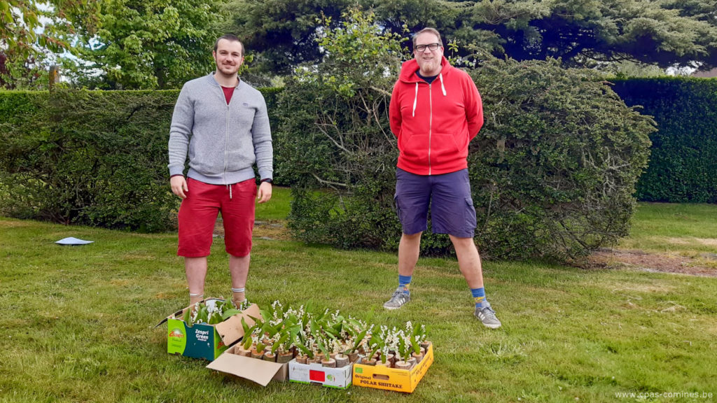 Deux membres du Club Human Impact dans un jardin avec leur récolte de muguet